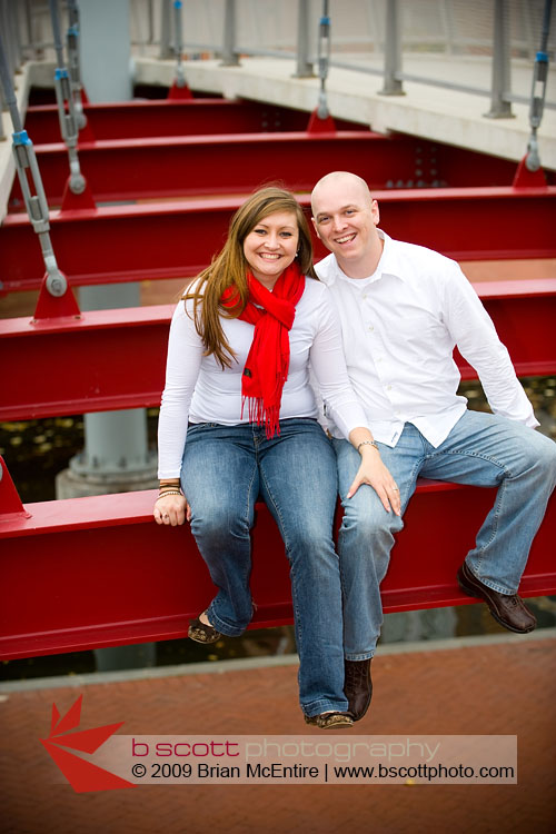 Couple sits atop exposed red I-beams of an architectural feature in downtown Frederick, MD.