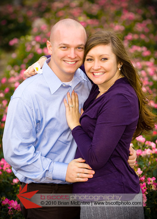 Traditional engagement photo pose, with added interest of defocused rose garden in the background.