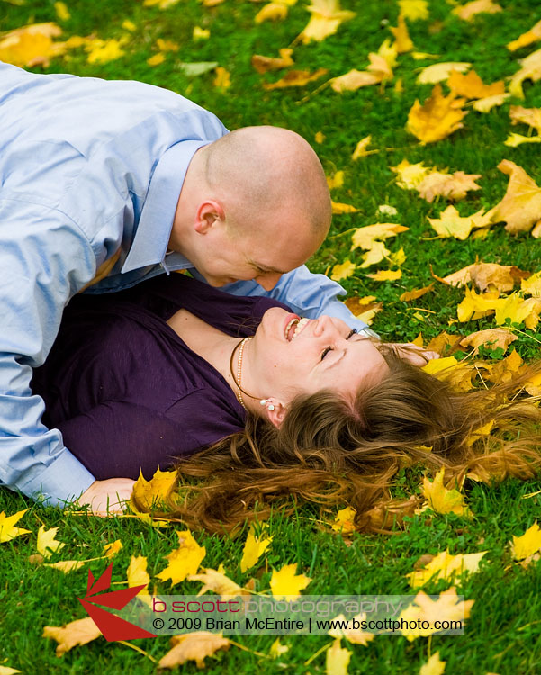 Playful couple among vibrant Fall colored leaves at Baker Park in Frederick, MD.