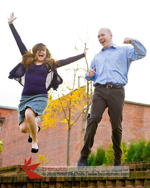 Jumping for joy: young, newly engaged couple leaps into the air.