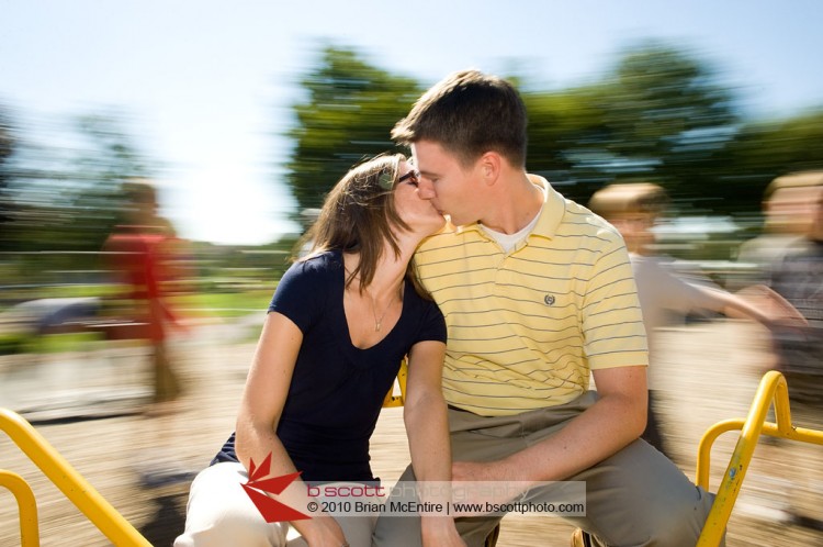 Coupe kissing on a carousel during an engagement shoot in Frederick, MD.