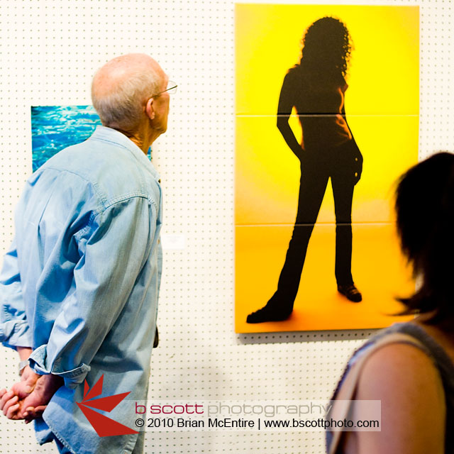 Man and woman viewing a 4 foot tall canvas triptych.